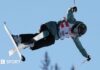 Winter Olympics 2026: How do extreme skiers overcome fear of serious injury? Freestyle skier Zoe Atkin is airborne, with only a blue sky and the tops of trees visible behind her