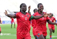 Wafcon 2026: Algeria 1-3 Malawi – Chawinga sisters fire Scorchers into final Malawi striker Tabitha Chawinga runs towards the touchline with arms spread wide to either side of her body to celebrate a goal at the 2026 Women's Africa Cup of Nations in Morocco. She wears all-red kit with green and black trim and is surrounded by a number of smiling team-mates who are running in her wake across the lush green pitch